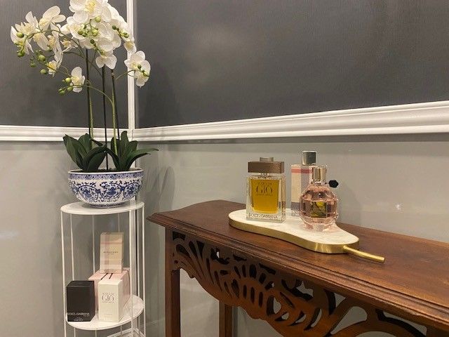 Two Bottles of Perfume Are Sitting on a Wooden Table — Ecotreat Solutions NT in Winnellie, NT