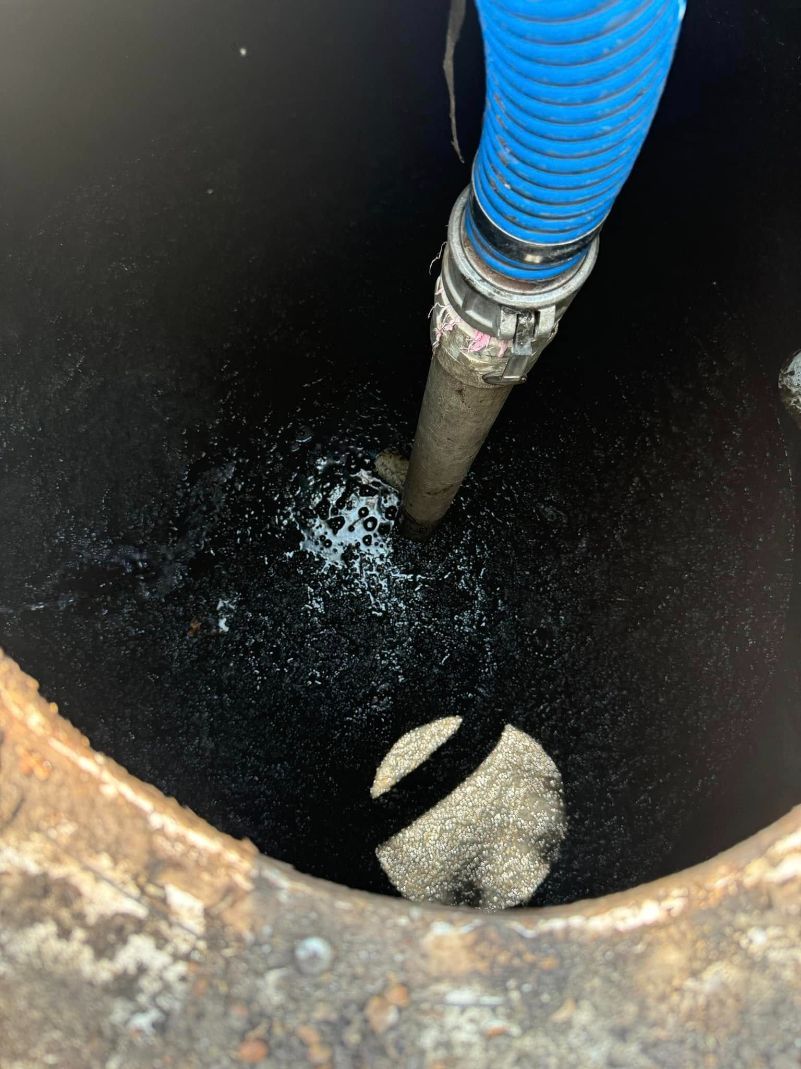 A Blue Hose is Being Used to Pump Water Into a Manhole — Ecotreat Solutions NT in Humpty Doo, NT
