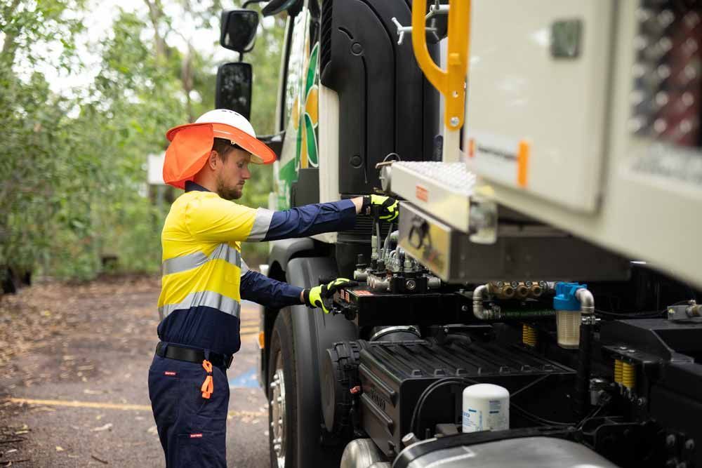 A Man is Working on the Back of a Truck — Ecotreat Solutions NT in Darwin Rural, NT