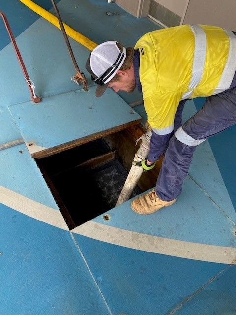 Man with Yellow Uniform Working Onsite Using Vacuum — Ecotreat Solutions NT in Winnellie, NT
