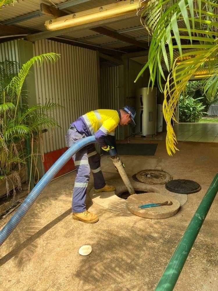 Man In Safety Gear Pumping A Septic Tank, Outdoors