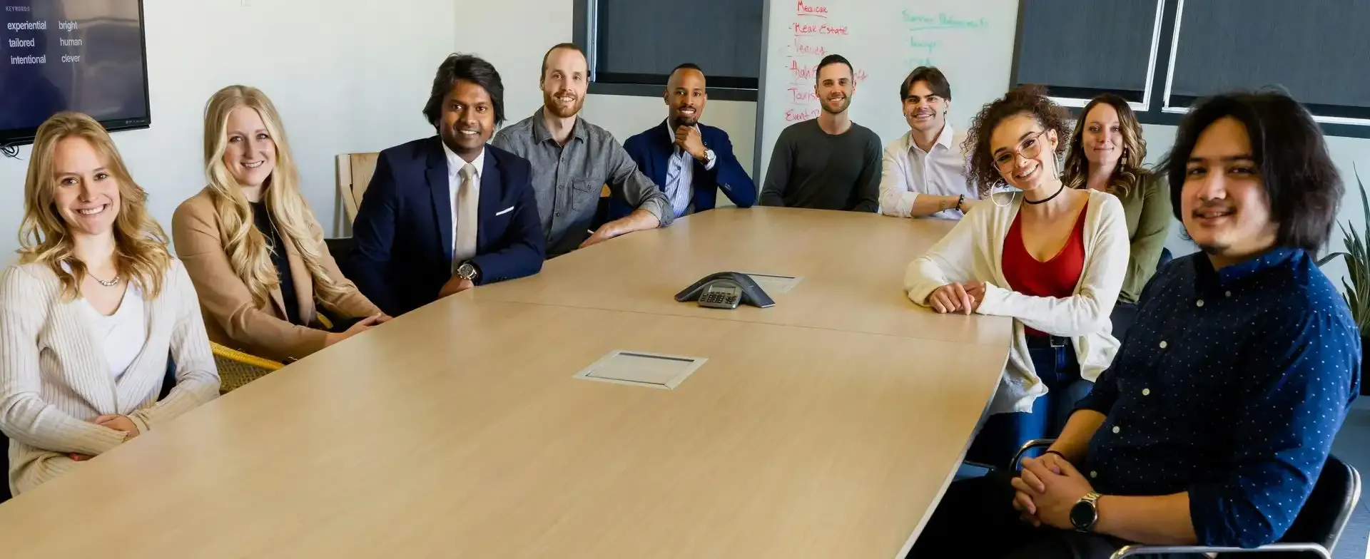 Group of people sitting at a table looking at a laptop