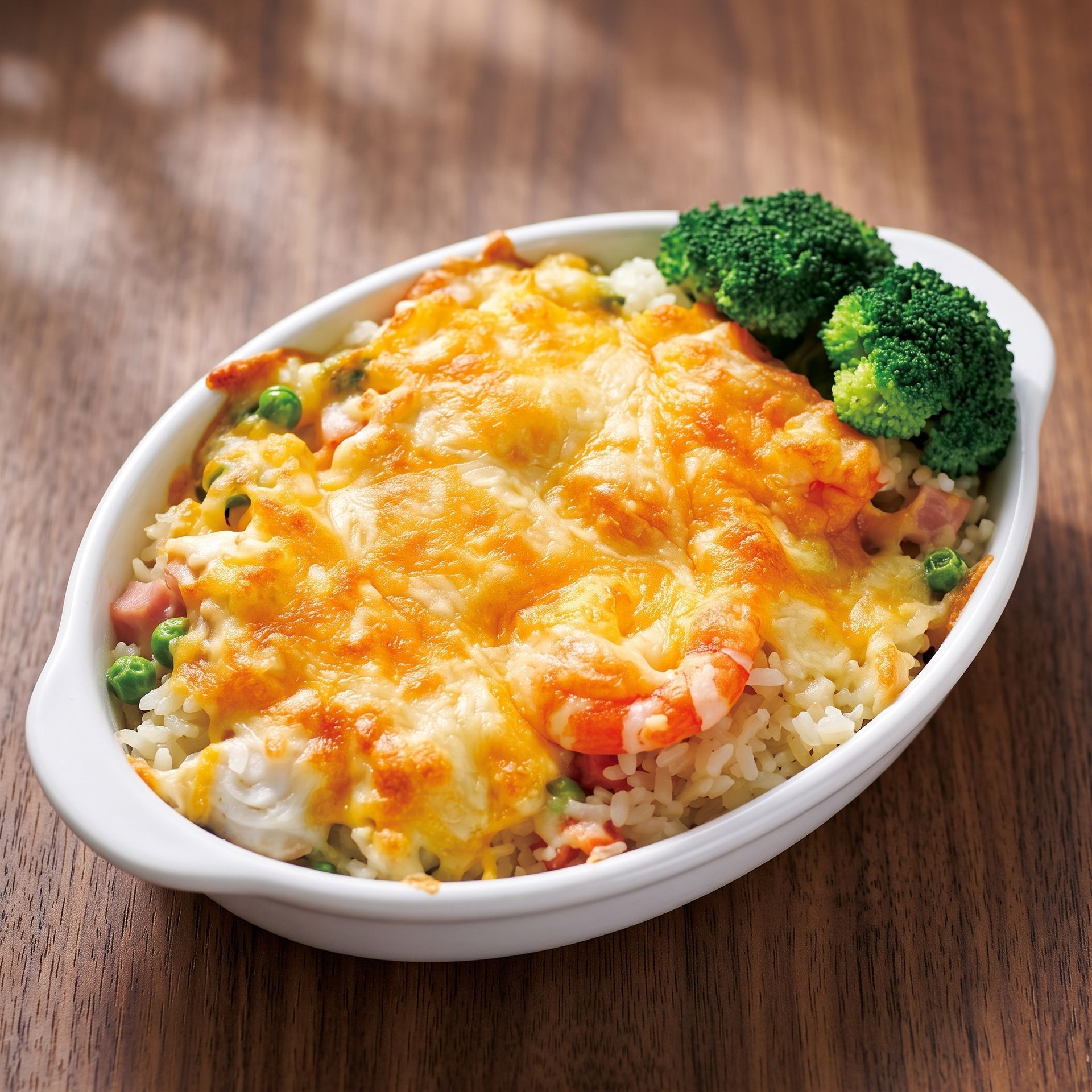 Baked cheesy rice casserole in a white dish, topped with broccoli, on a wooden table