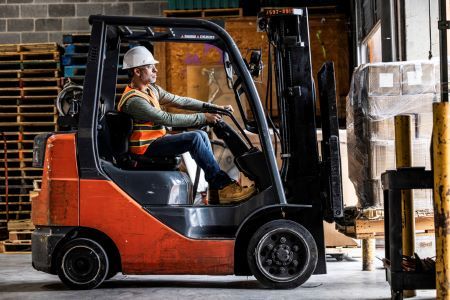 a man is driving a forklift in a warehouse .