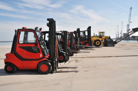 a row of forklifts are parked next to each other in a parking lot