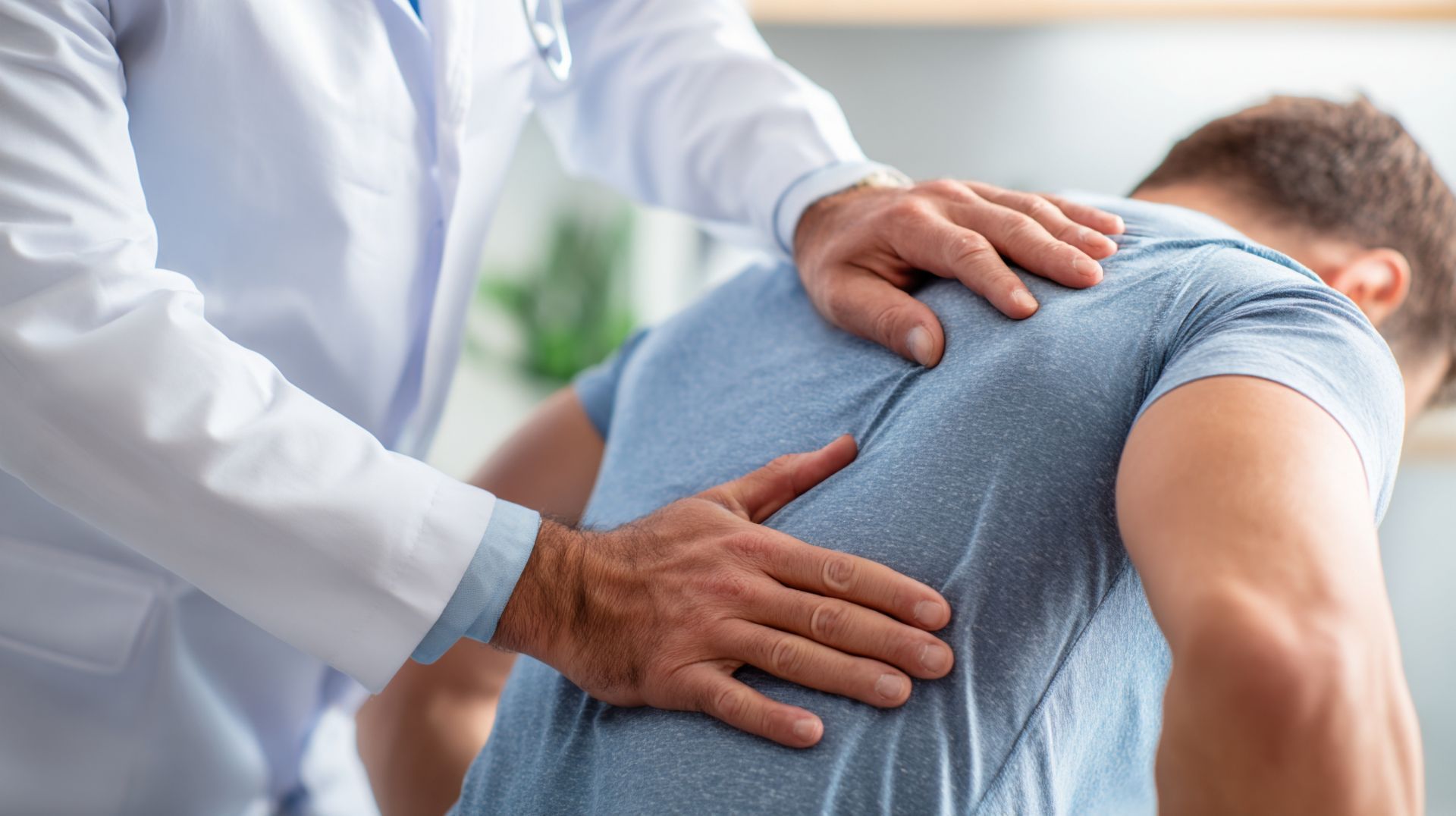 Chiropractor performing a hands-on spinal adjustment on a male patient’s back during a chiropractic