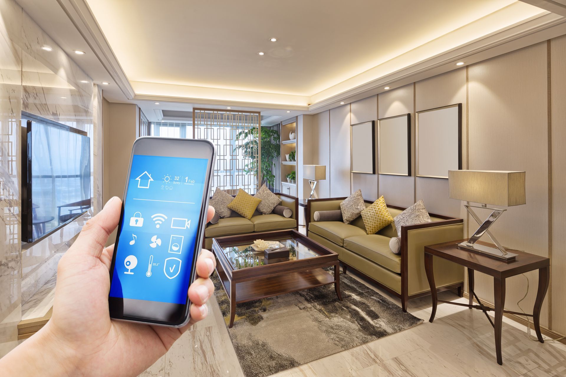 Hand holding a smartphone with a smart-home app in a modern living room