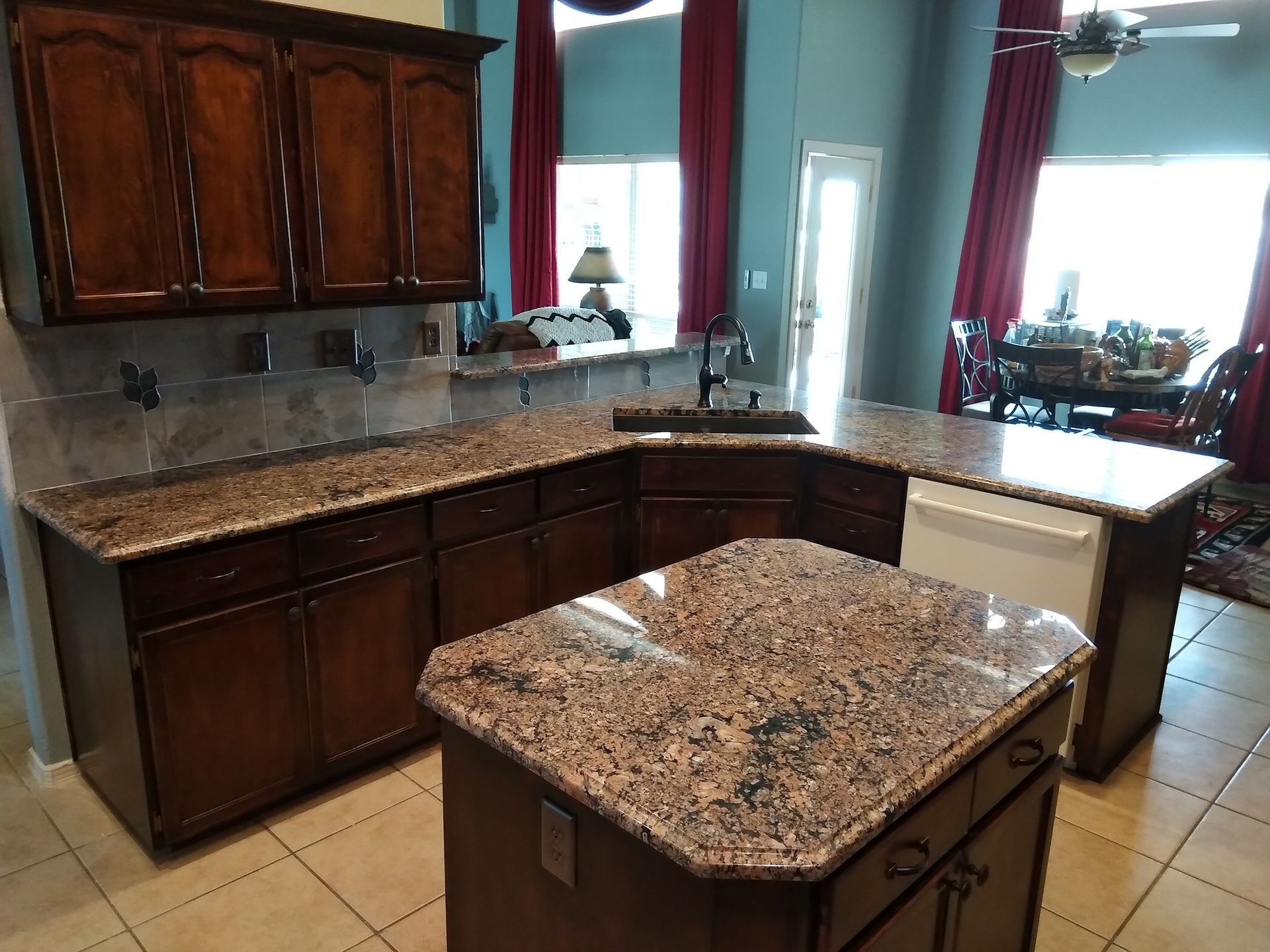 Kitchen with brown cabinets, granite countertops, and an island.