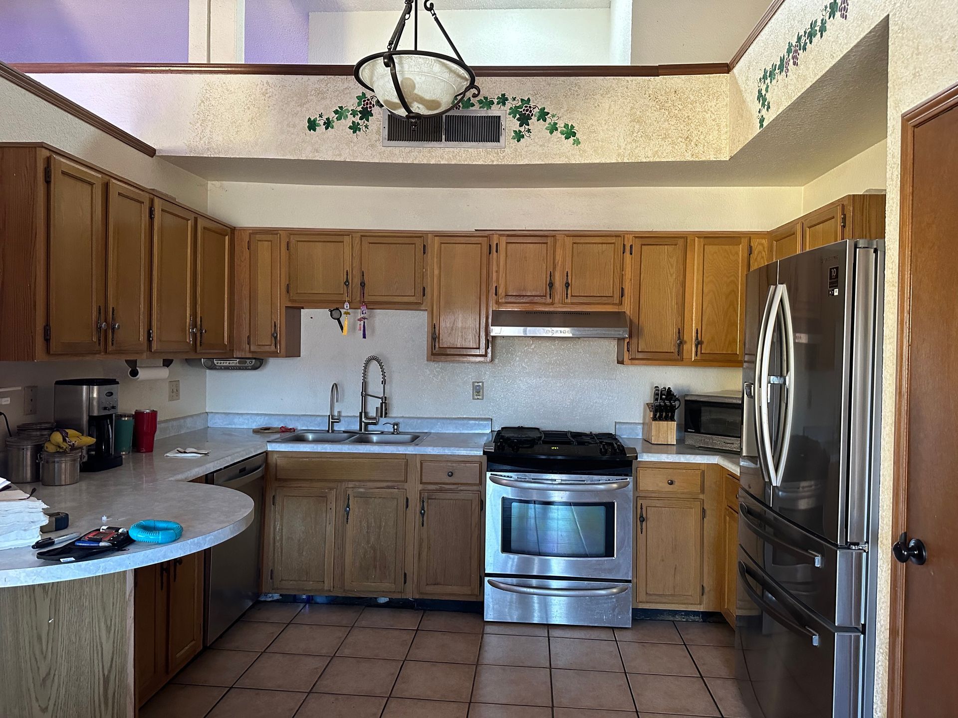 Kitchen with light wood cabinets, stainless steel appliances, and a white countertop.