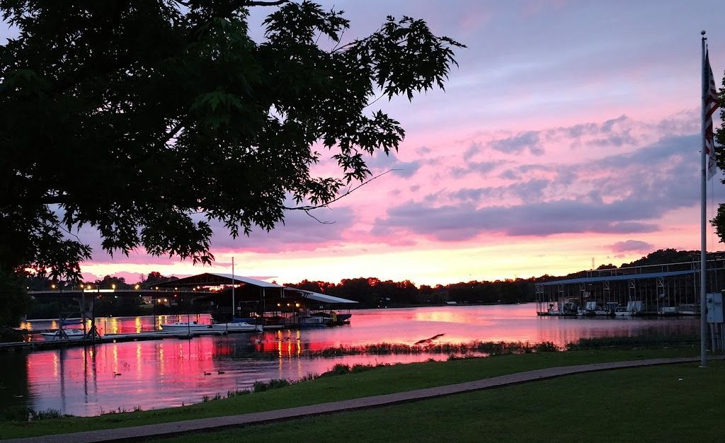 Sunset over the marina, with pink clouds reflected in the water and covered docks on both sides