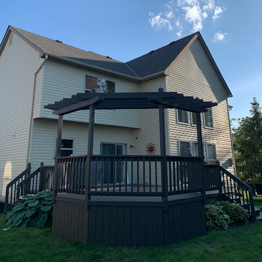 A house with a deck and a pergola in front of it