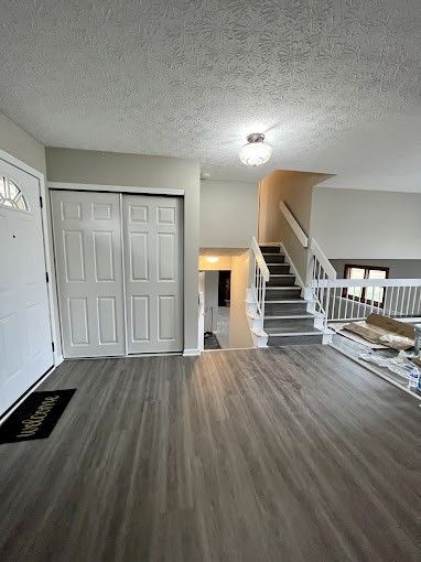 A living room with hardwood floors and stairs leading up to the second floor.