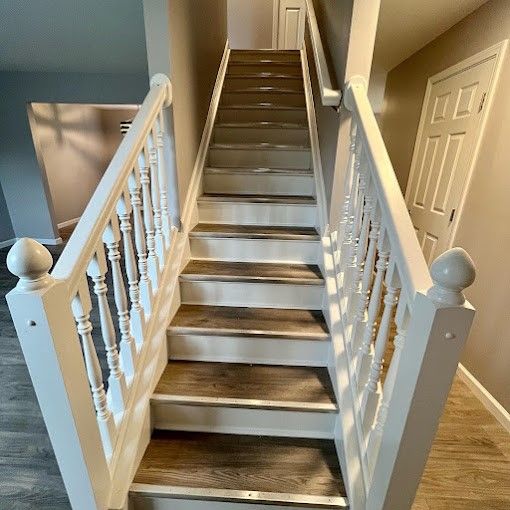A staircase with wooden steps and a white railing in a house.