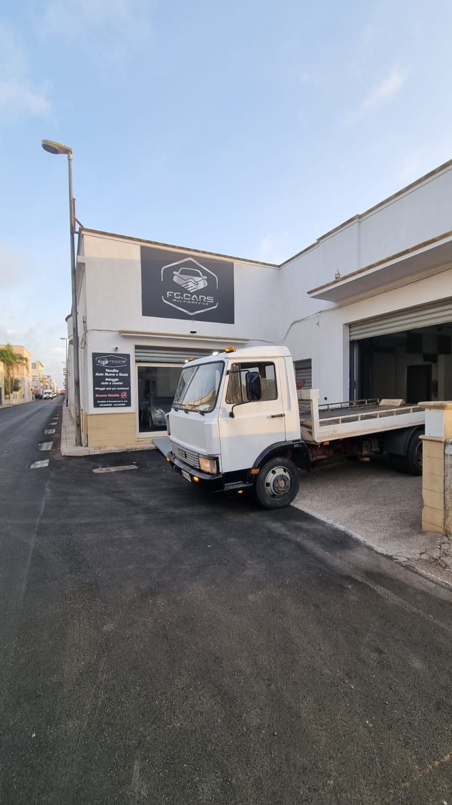 Un carro attrezzi bianco è parcheggiato davanti a un edificio.