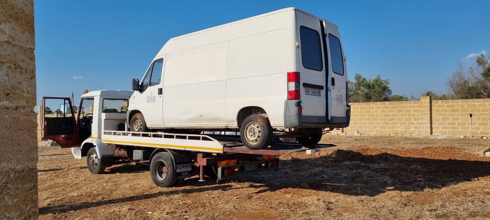 Un furgone bianco viene trainato da un carro attrezzi.