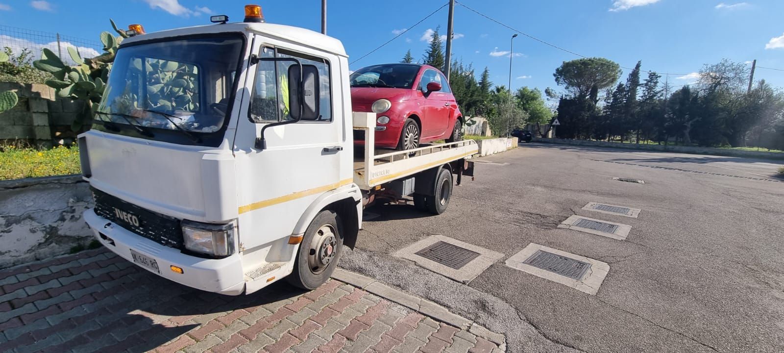 Un carro attrezzi trasporta un'auto rossa sul retro.