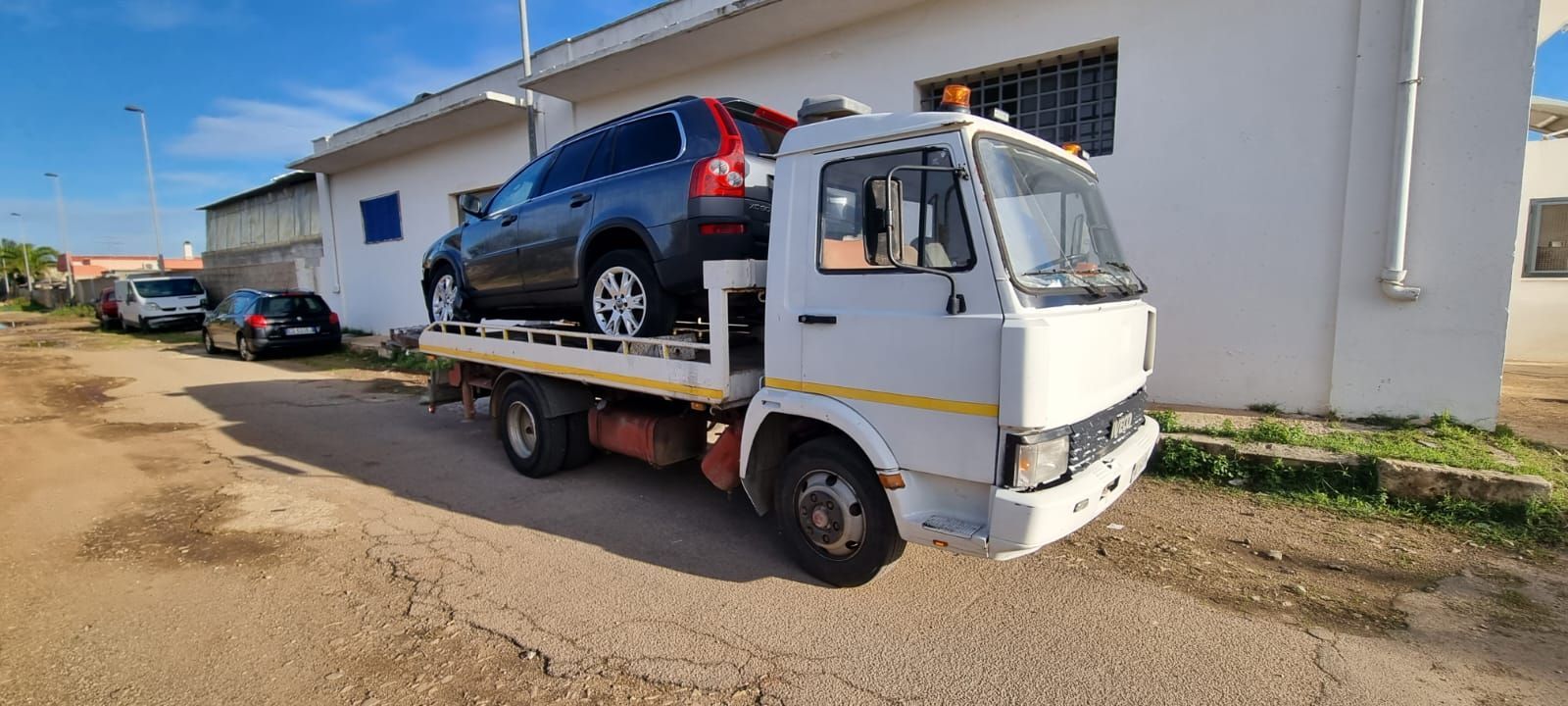 Un carro attrezzi trasporta un'auto sul retro.