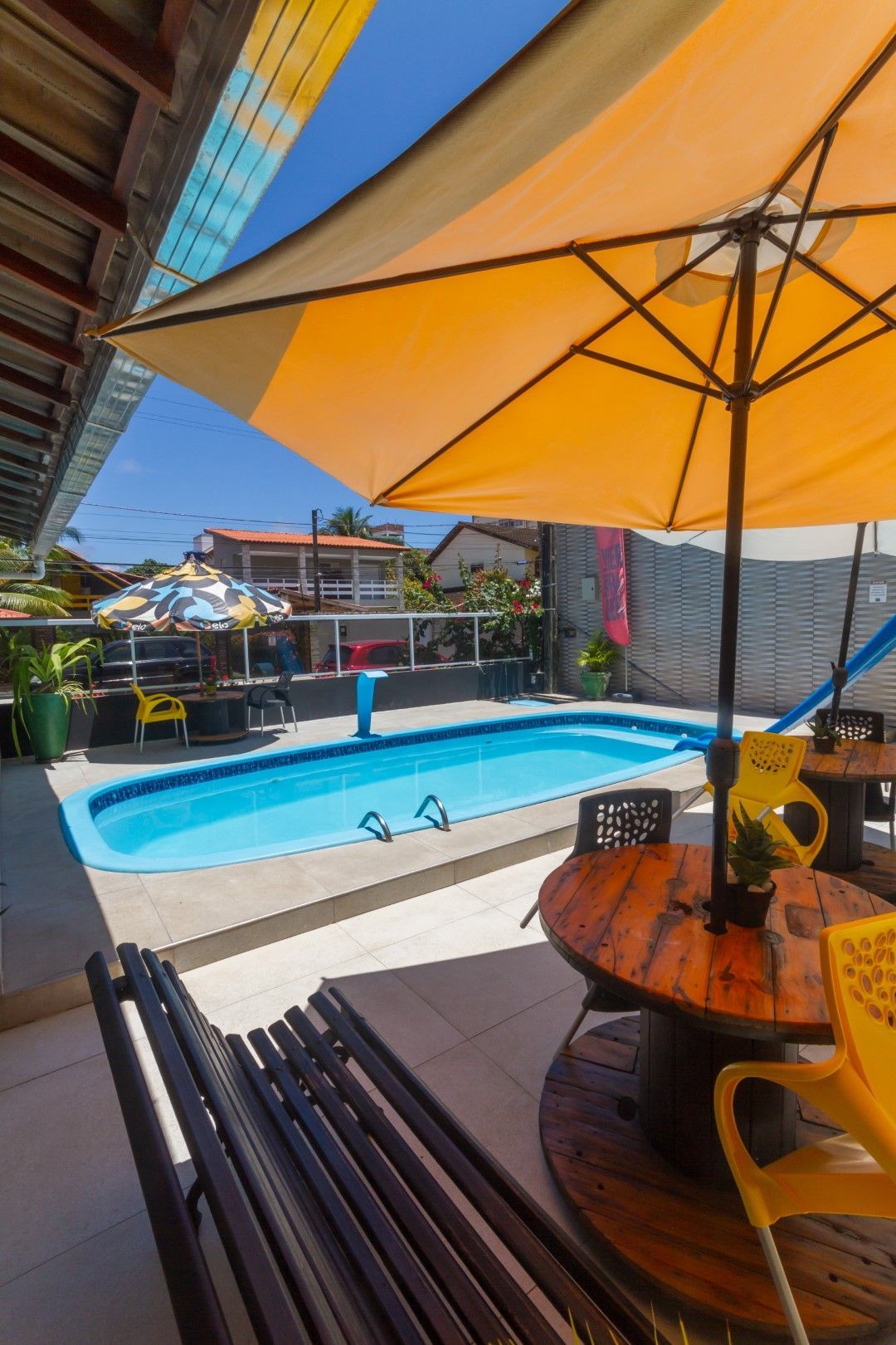 Uma piscina com mesa e cadeiras sob um guarda-sol