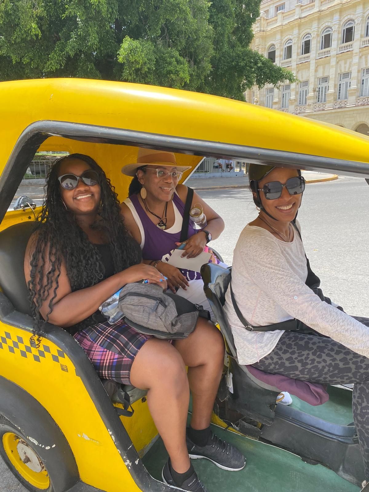 black women riding Coco Taxi in Havana