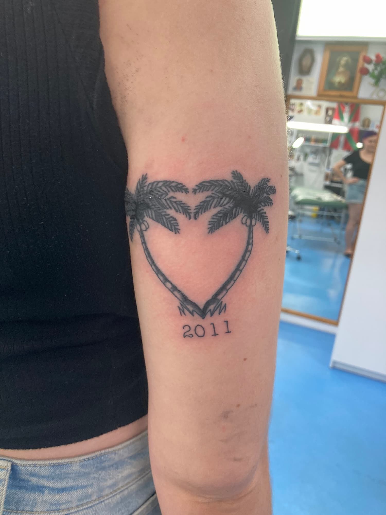 A Tattoo of Palm Trees in the Shape of a Heart With the Year 2011 — La Bomba Loca Tattoo in Cairns City, QLD