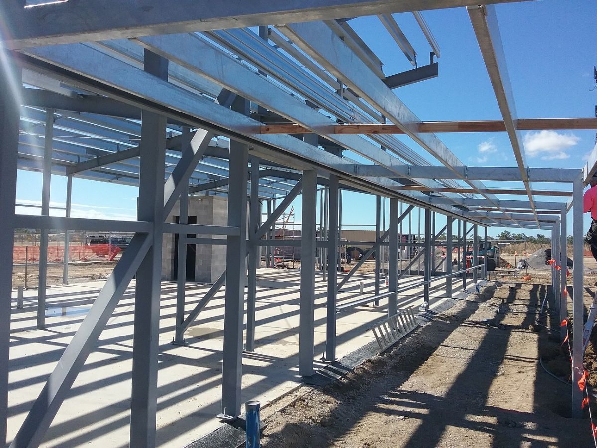 Metal Frame Construction Of A Building Under A Blue Sky — Custom Steel Fab in Garbutt, QLD