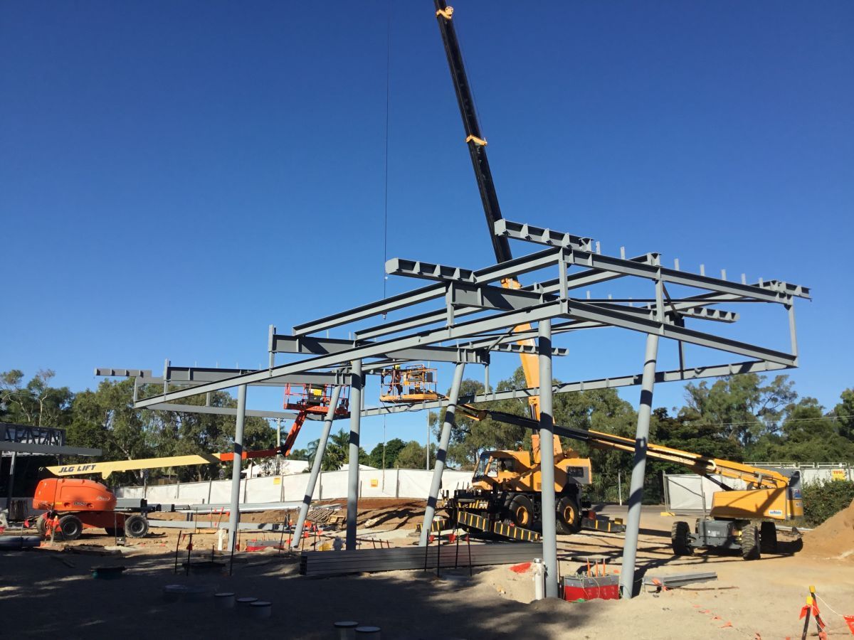 Construction Site With A Crane Lifting Steel Beams — Custom Steel Fab in Garbutt, QLD