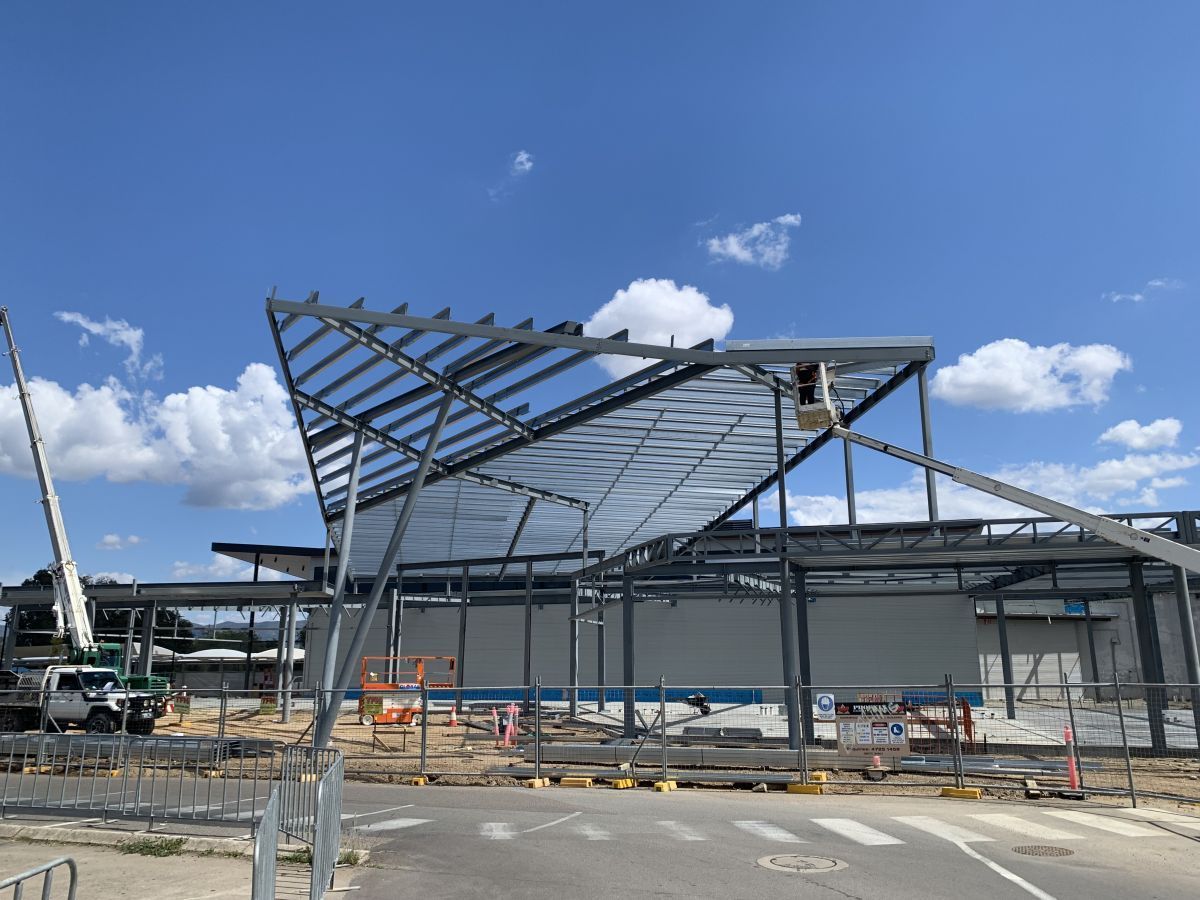 Steel Frame Of A Building Under Construction Against A Blue Sky With Clouds — Custom Steel Fab in Garbutt, QLD