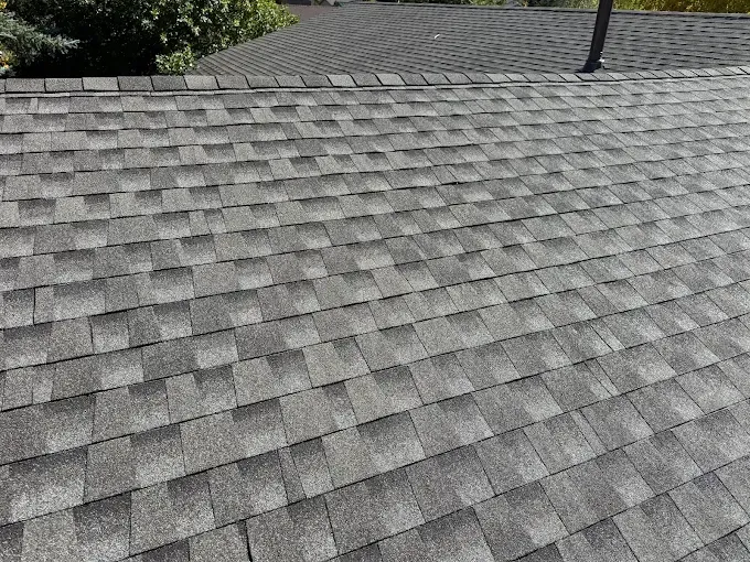 Gray shingled roof with a vent pipe near the ridge line