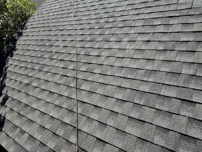 Gray shingled roof with a vertical seam or flashing strip down the center