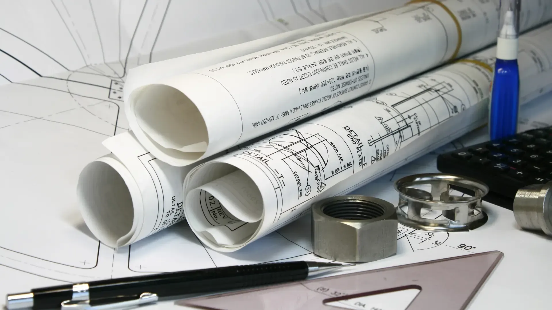 Several rolls of drawings are stacked on top of each other