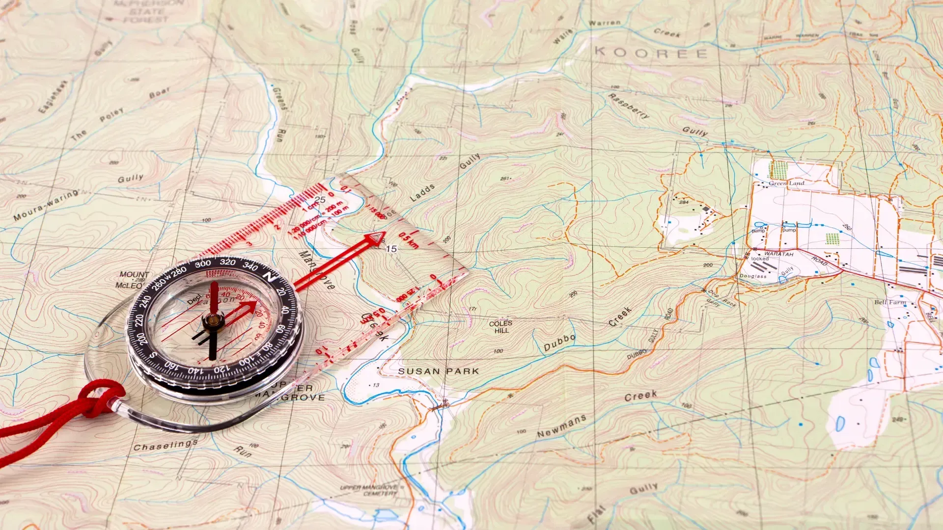 A compass is sitting on top of a map.