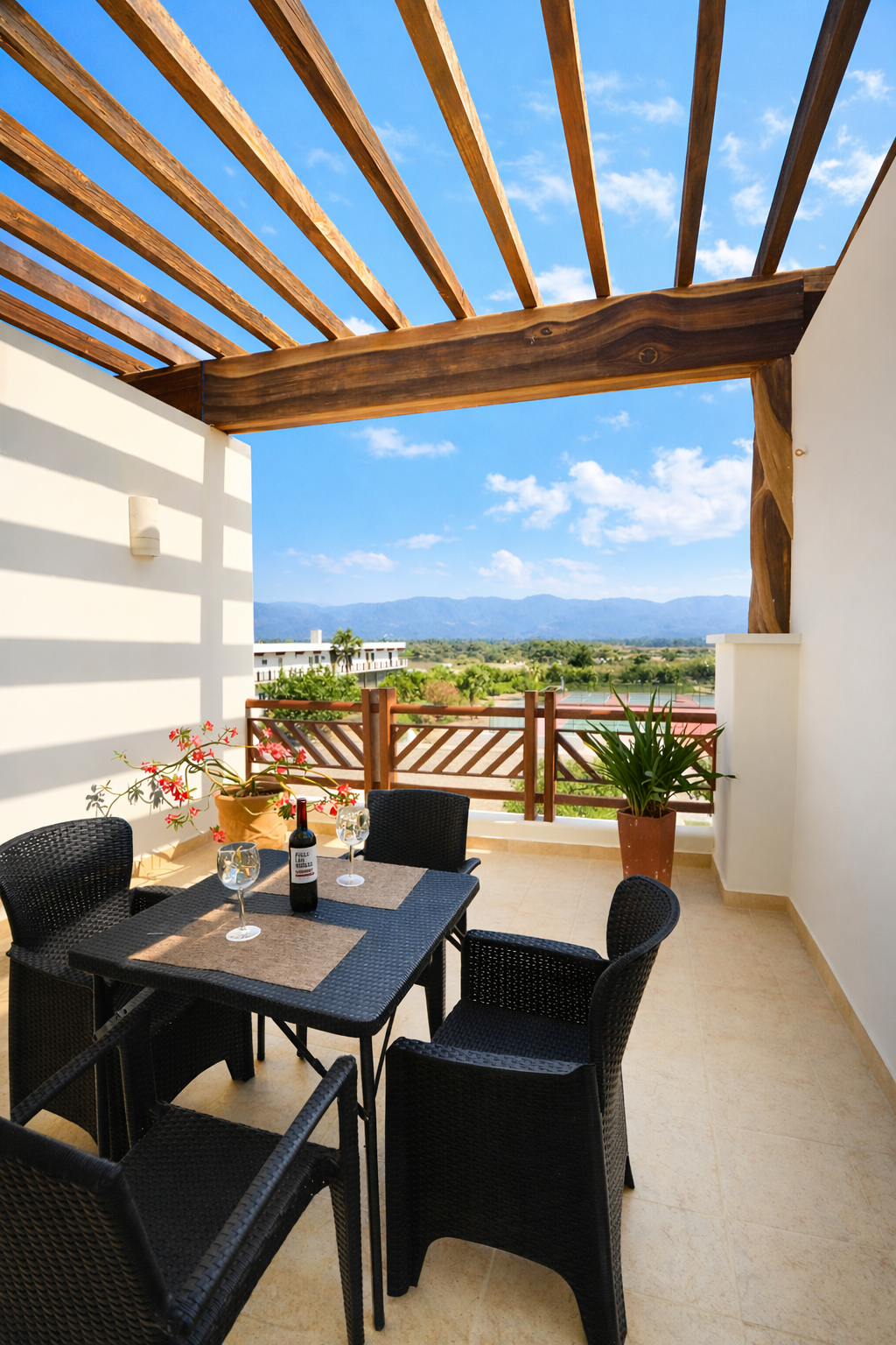 Outdoor terrace with black dining chairs, wooden pergola, and sea view beyond railing