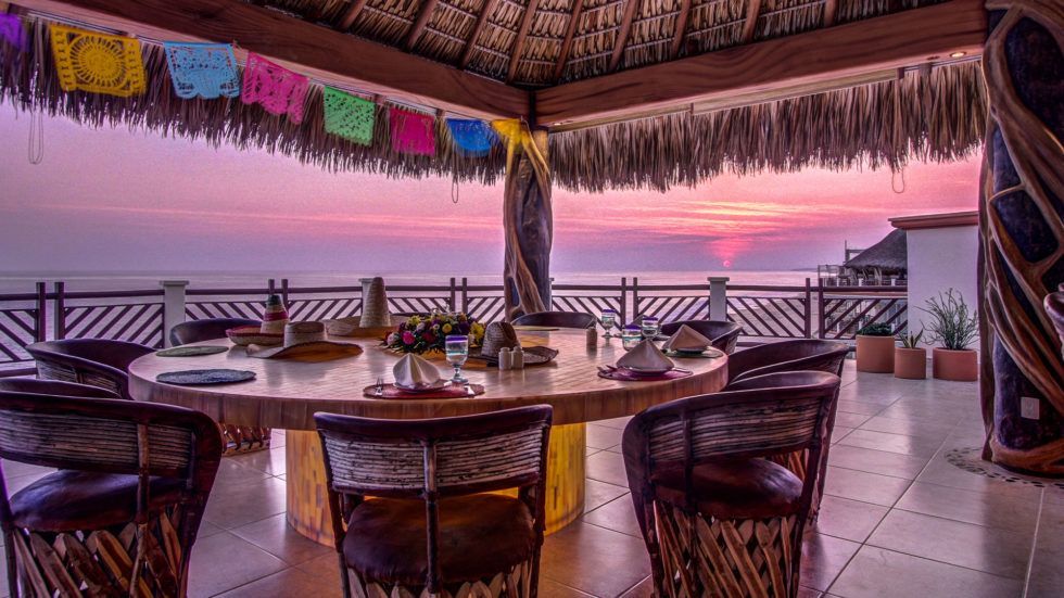 Vivo Resort outdoor dining area with ocean view, and sunset.