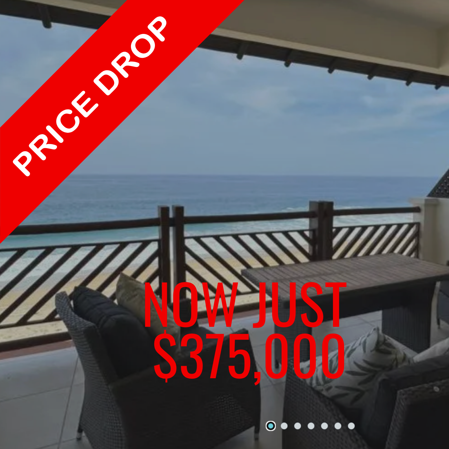Balcony overlooking ocean; wicker furniture, wood railing, blue sky.