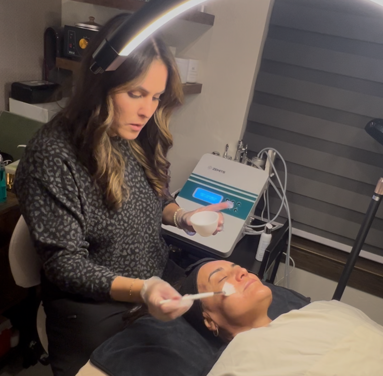 A woman is applying a cream to a man 's face