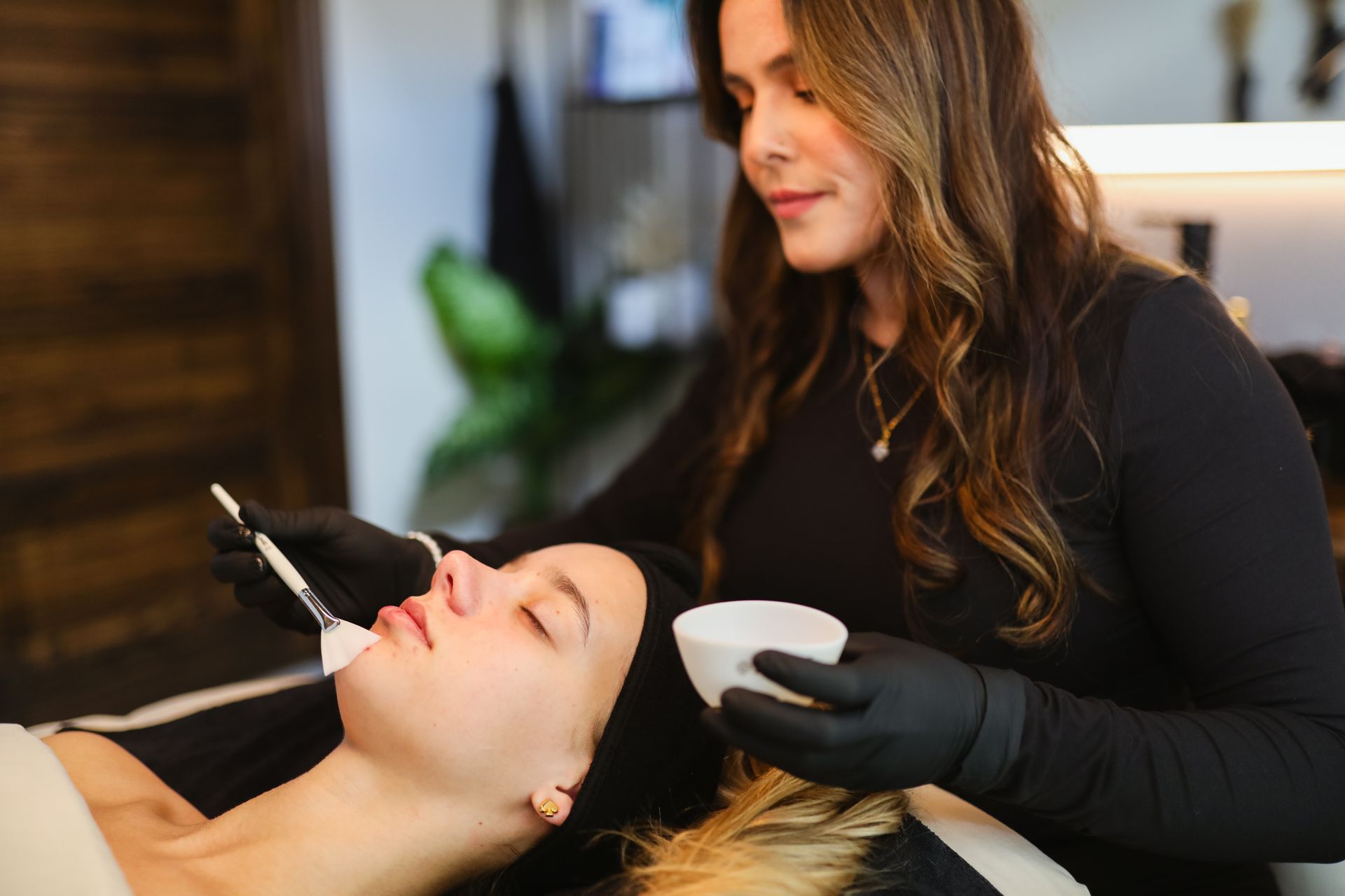 A woman is getting a facial treatment at a beauty salon.