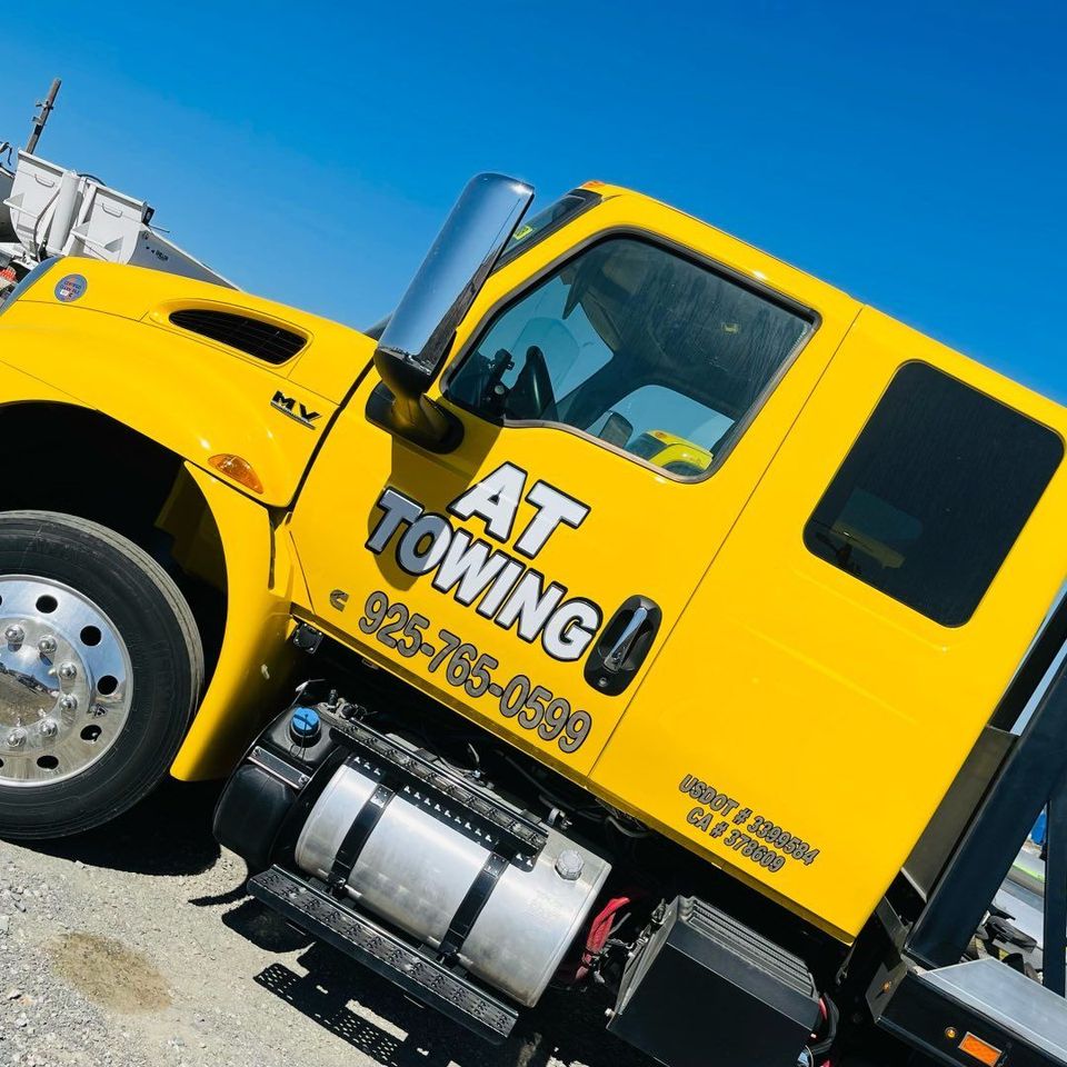 Close-up of the yellow AT Towing service truck cab