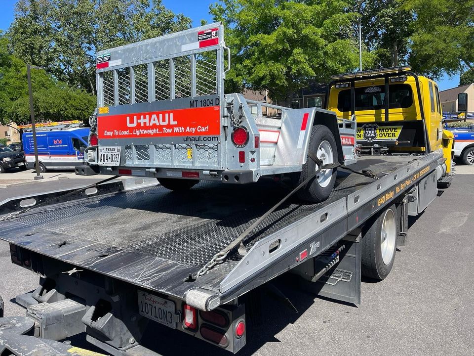 Utility trailer loaded on an AT Towing flatbed