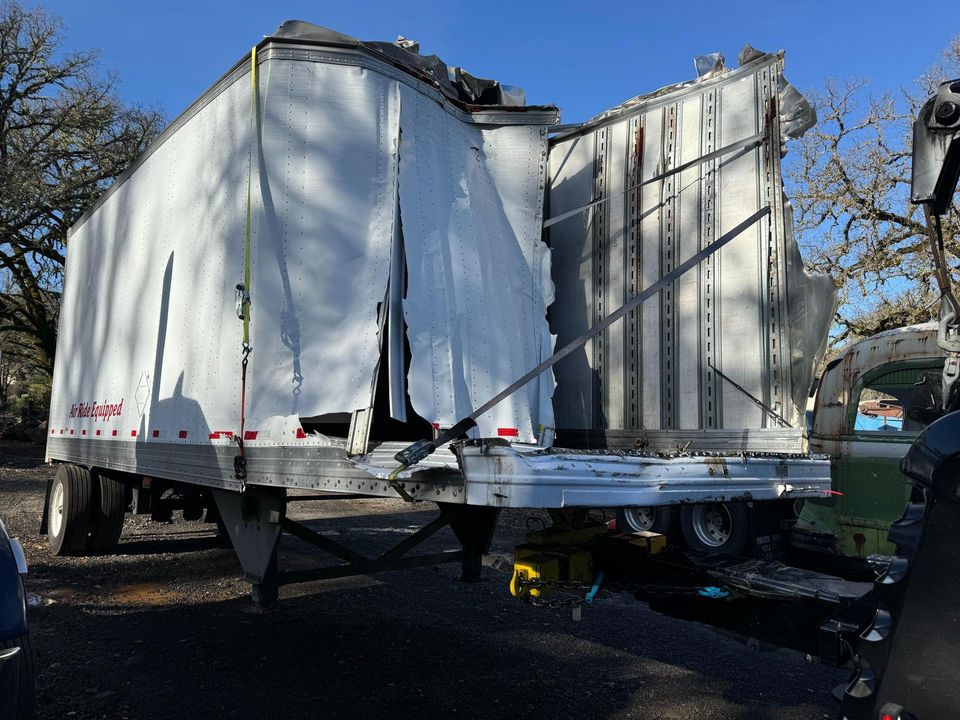 Two damaged dry-van trailers positioned in the recovery yard