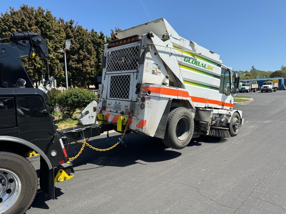Street sweeper hooked to the AT Towing heavy wrecker
