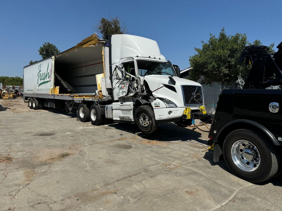 Damaged semi tractor and trailer staged for recovery