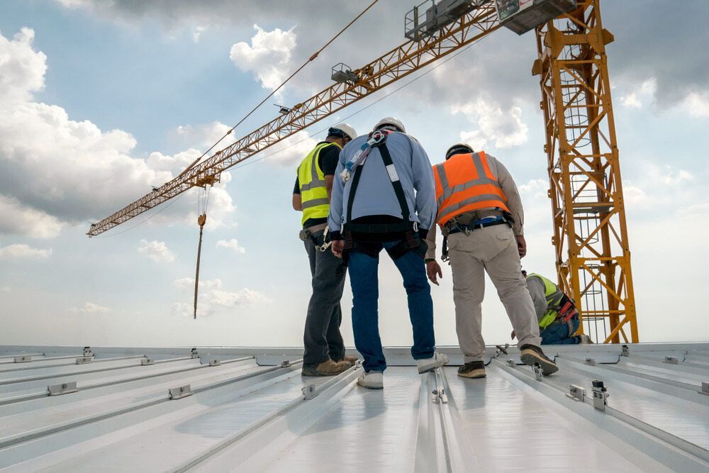 A Group of Construction Workers Are Standing on Top of a Roof — Aspex Construction - Lou Pieren In Port Macquarie, NSW