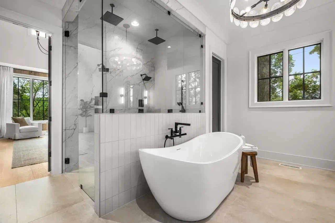 Modern bathroom with freestanding tub, glass shower, and light wood flooring