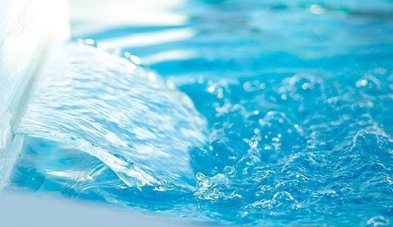 Blue water cascading and splashing, creating ripples.