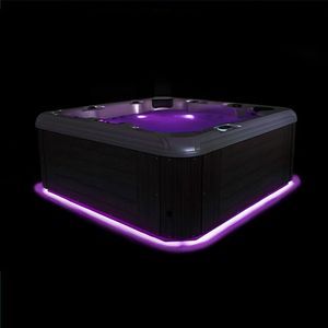 A square hot tub with dark wood siding, glowing purple water, and ambient purple lighting along the base on a black background.