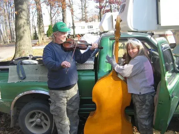 A man playing a violin next to a woman holding a double bass