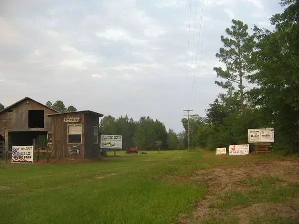 A wooden building in the middle of a grassy field