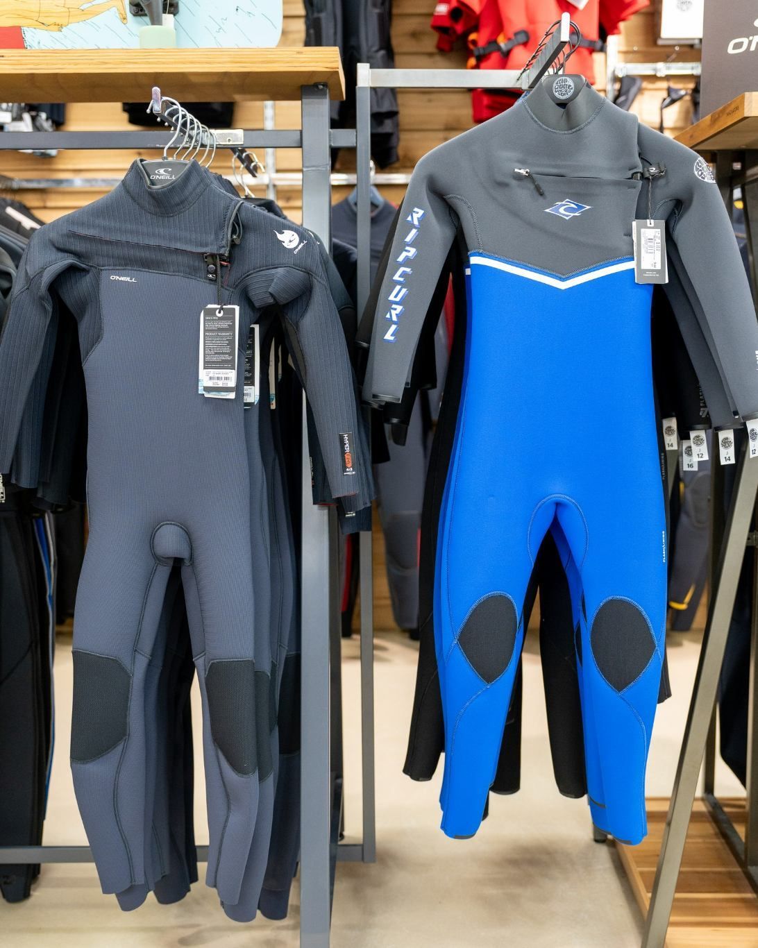Two Wetsuits Are Hanging on A Rack in A Store — Slimes Boardstore in Bateau Bay, NSW