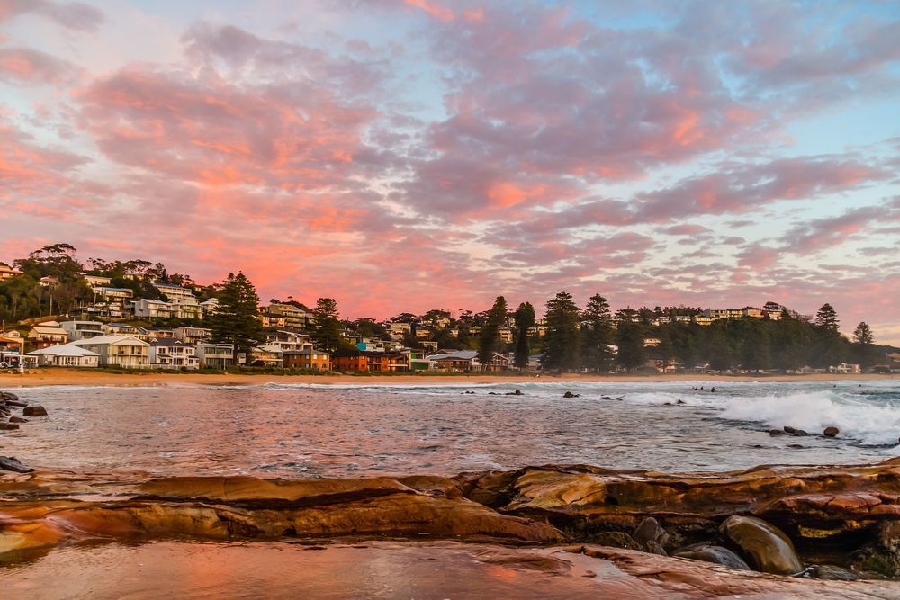 A Sunset Over a Beach with A City in The Background — Slimes Boardstore in Avoca, NSW