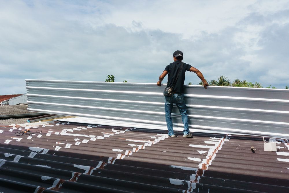 A Man is Replacing a Roof — Woodger's Metal Roofing Specialists Pty Ltd in Nambucca Heads, NSW